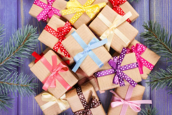 Τυλιγμένα δώρα με πολύχρωμες κορδέλες για τα Χριστούγεννα και ερυθρελάτης κλαδιά — Φωτογραφία Αρχείου