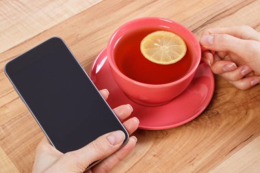 Boş ekran cep telefonu, çay dokunmadan kadının el