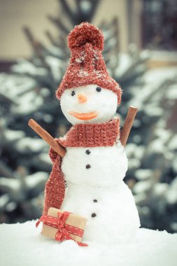 Vintage Fotoğraf, kardan adam ile iğne yapraklı ağaç arka plan üzerinde Noel ya da Sevgililer günü için hediye kar kaplı.