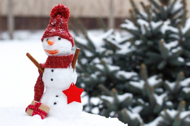 Kar kardan adam iğne yapraklı ağaç arka plan üzerinde Noel ya da Sevgililer günü için hediye ile kaplı