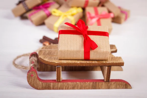 Ξύλινο έλκηθρο και τυλιγμένα δώρα για τα Χριστούγεννα ή άλλη γιορτή — Φωτογραφία Αρχείου