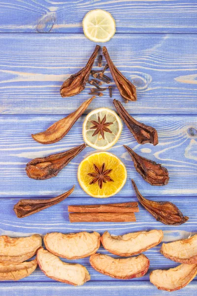 Christmas tree shape made of dried fruits and spices on wooden boards — Stock Photo, Image