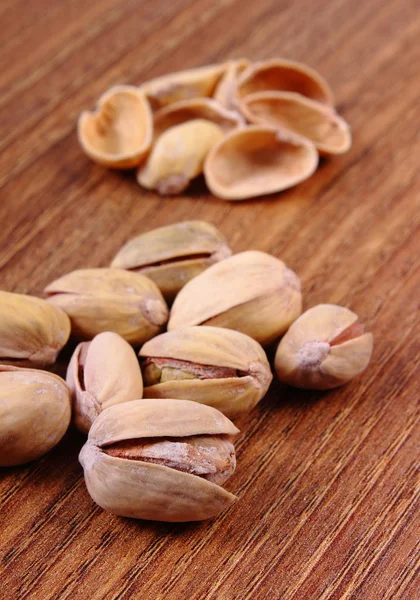 Pistacchi con gusci sul tavolo di legno, alimentazione sana — Foto Stock