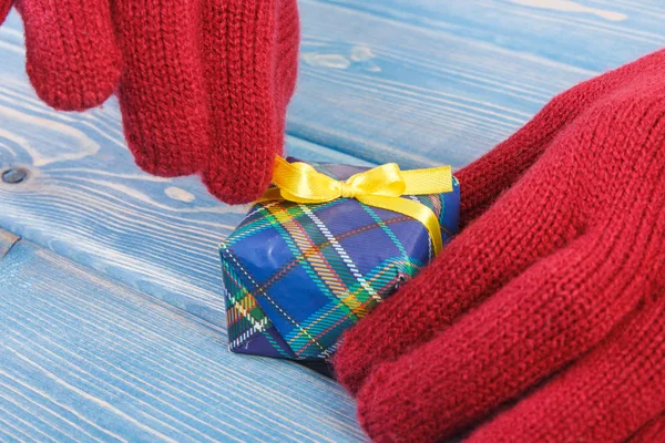 Mains de femme en gants déballer cadeau pour Noël ou autre célébration — Photo