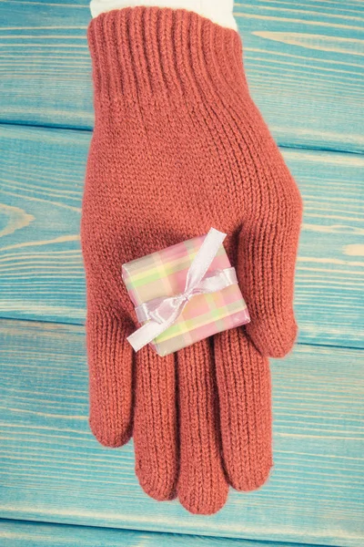 Foto vintage, Mano de mujer en guantes con regalo para Navidad u otra celebración —  Fotos de Stock