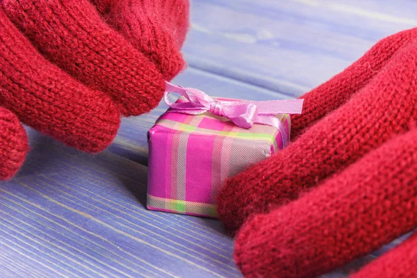 Mains de femme en gants déballer cadeau pour Noël ou autre célébration — Photo