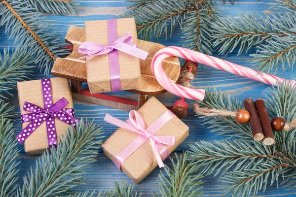 Trineo de madera y regalos envueltos con cintas para Navidad, ramas de abeto — Foto de Stock