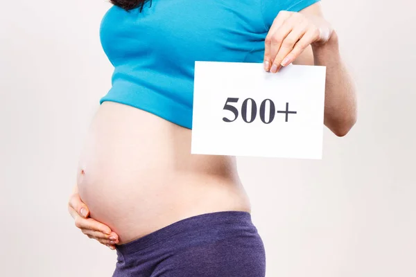 Zwangere vrouw houden kaart met inscriptie 500 +, sociaal programma en beleid in Polen — Stockfoto