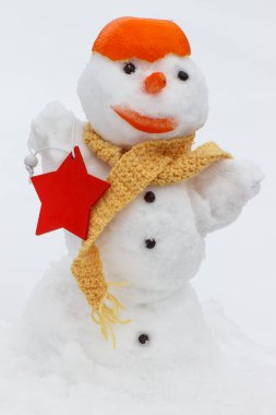 Kardan adam eşarp ve mandalina kabuğu, arka plan beyaz kar ile dekore edilmiş