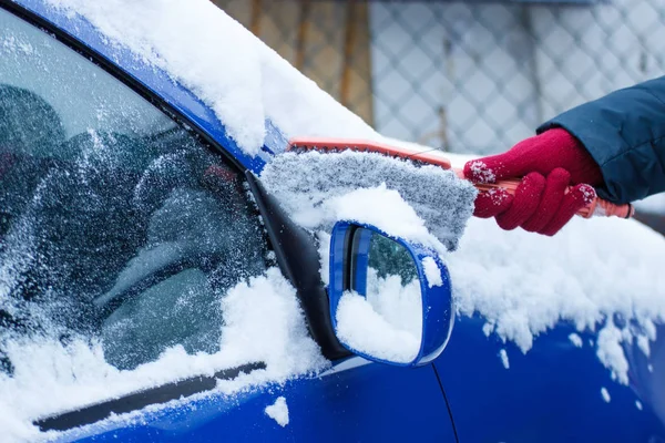 Hand av kvinna med borste och ta bort snö från bilen, vindrutan och spegel — Stockfoto