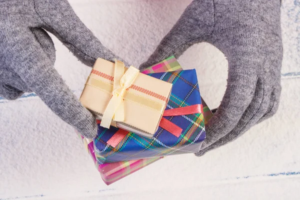Τα χέρια της γυναίκας στα γάντια με δώρο για τα Χριστούγεννα ή άλλη γιορτή — Φωτογραφία Αρχείου