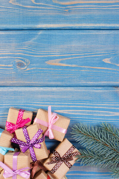 Wrapped gifts with colorful ribbons for Christmas and spruce branches, copy space for text