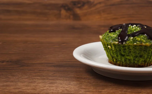Frischer Muffin mit Spinat, Kokosraspeln und Schokoglasur, leckeres gesundes Dessert, Platz für Text — Stockfoto