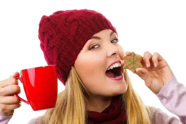 Donna sorridente in berretto di lana e scialle con biscotti di pan di zenzero e tè, sfondo bianco, periodo natalizio — Foto Stock