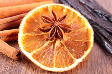 Yıldız anason, kokulu vanilya, tarçın ve ahşap yüzey üzerinde kurutulmuş portakal