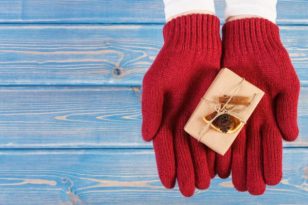 Mãos de mulher em luvas com presente decorado para o Natal ou outra celebração, espaço de cópia de texto — Fotografia de Stock