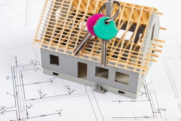 Home keys and small house under construction on electrical drawings, building home concept — Stock Photo, Image