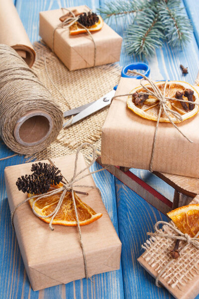 Аксессуары, украшения и завернутые подарки на Рождество с деревянными санями на досках
