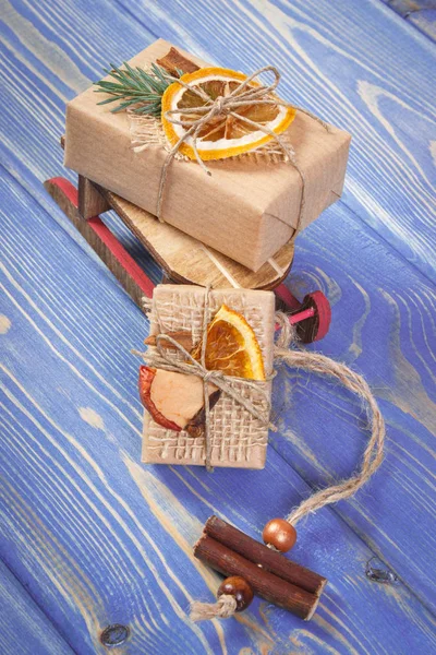 Sled de madeira, presentes embrulhados com decoração para o Natal ou outra celebração em placas — Fotografia de Stock