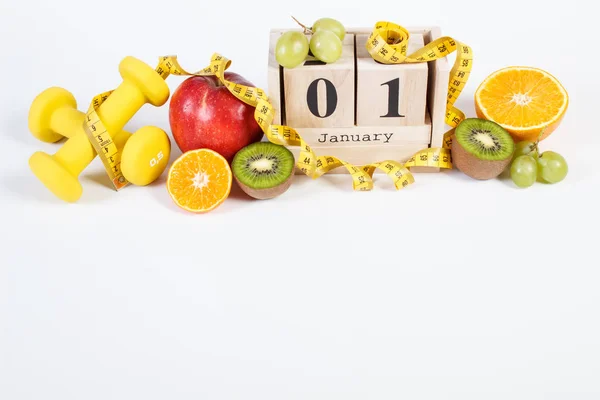 Calendario de cubos, frutas, mancuernas y cinta métrica, resoluciones de año nuevo —  Fotos de Stock