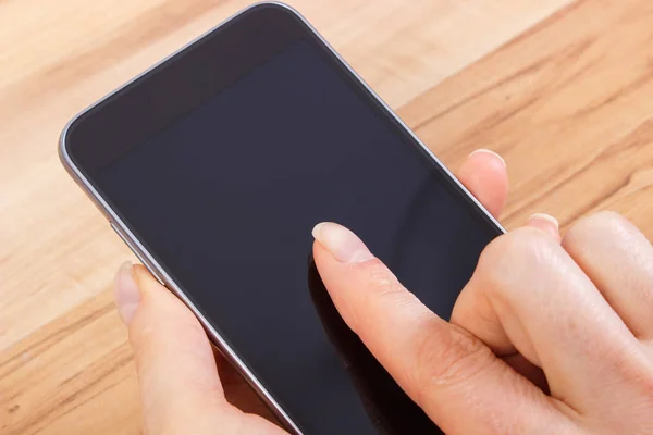 Рука женщины касается пустого экрана мобильного телефона — стоковое фото