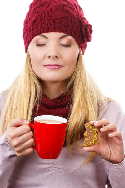 Donna in berretto e scialle in possesso di pan di zenzero e tazza di tè caldo, periodo natalizio — Foto Stock