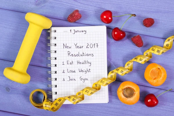 Новорічні резолюції, написані в блокноті на фіолетовій дошці — стокове фото