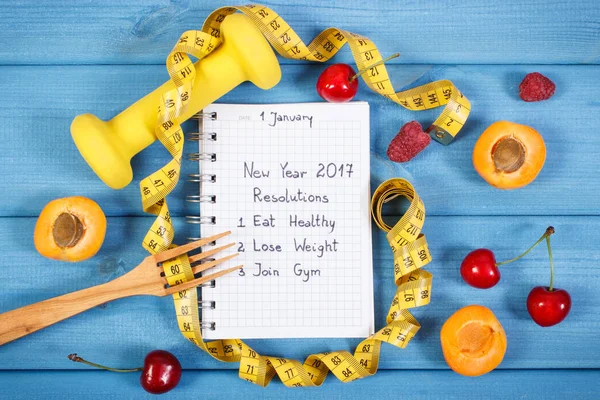 Neujahrsvorsätze in Notizbuch auf blauer Tafel geschrieben — Stockfoto