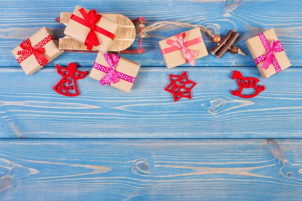 Ξύλινο έλκηθρο και τυλιγμένα δώρα με κορδέλες για τα Χριστούγεννα ή άλλης γιορτής, αντίγραφο χώρου για το κείμενο — Φωτογραφία Αρχείου