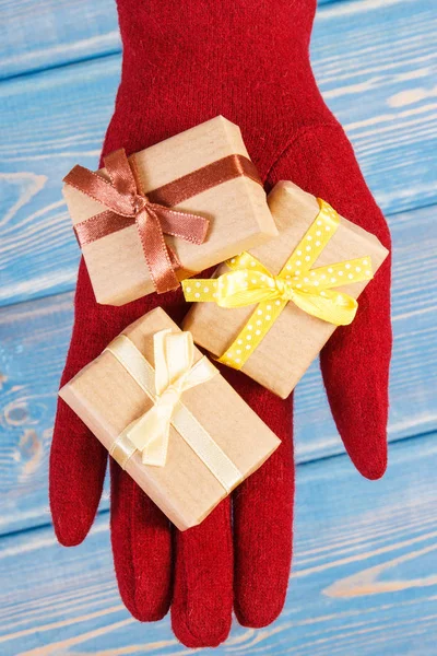 Το χέρι της γυναίκας στα γάντια με δώρα για τα Χριστούγεννα ή άλλη γιορτή — Φωτογραφία Αρχείου