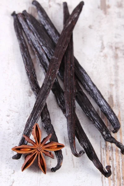 Fragrante vaniglia e anice stellato su vecchia tavola di legno — Foto Stock