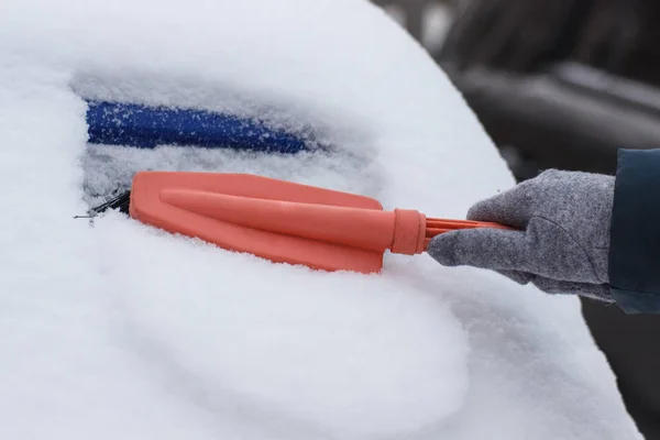 Hand of woman using brush and remove snow from car and windscreen — Stock Photo, Image