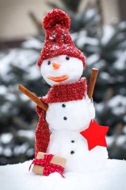 Kar kardan adam iğne yapraklı ağaç arka plan üzerinde Noel ya da Sevgililer günü için hediye ile kaplı