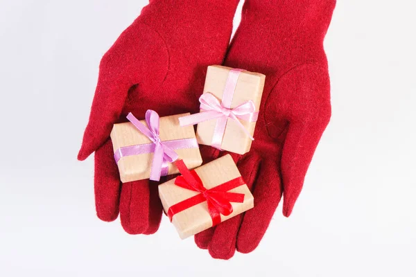 Manos de mujer en guantes con regalos para Navidad u otra celebración —  Fotos de Stock