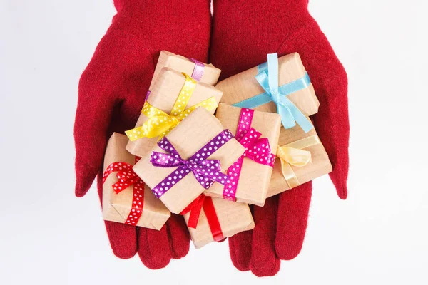 Mains de femme en gants avec des cadeaux pour Noël ou toute autre célébration — Photo