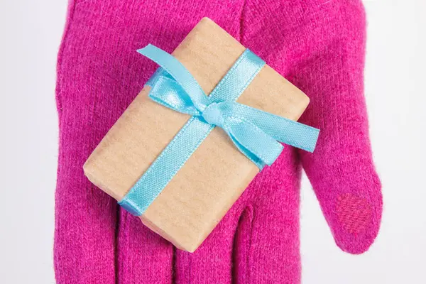 Το χέρι της γυναίκας στα γάντια με δώρο για τα Χριστούγεννα ή άλλη γιορτή — Φωτογραφία Αρχείου