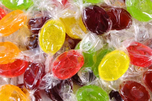 Montón de caramelos de colores como fondo, demasiados dulces — Foto de Stock