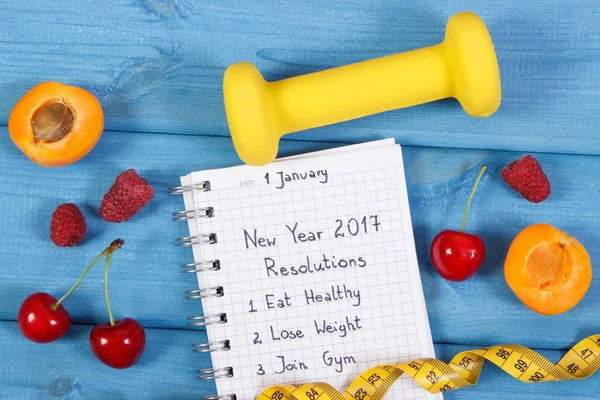 Resoluciones de año nuevo escritas en cuaderno en tablero azul — Foto de Stock