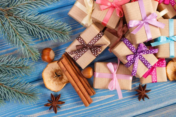 Inslagna presenter med band till jul, kryddor och spruce grenar — Stockfoto