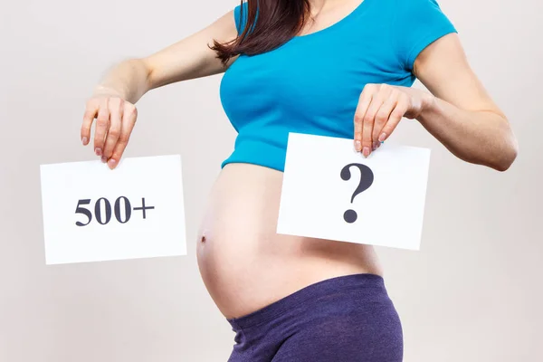 Zwangere vrouw houden kaart met inscriptie 500 + en vraagteken, sociaal programma en beleid in Polen — Stockfoto