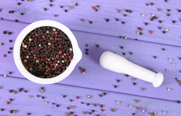 Kleurrijke peper in witte mortel op paarse boards — Stockfoto