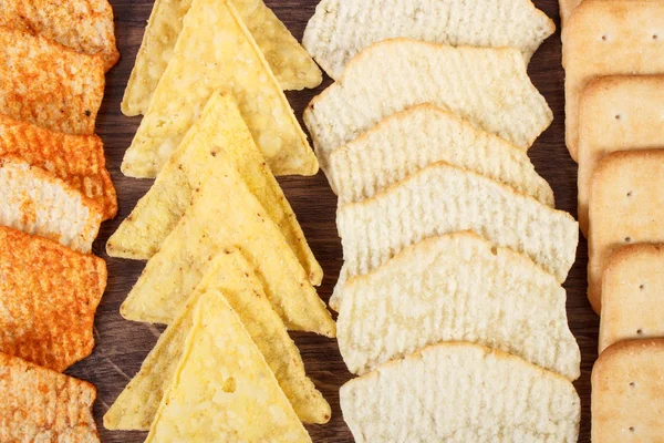 Galletas crujientes y patatas fritas saladas, concepto de comida poco saludable — Foto de Stock