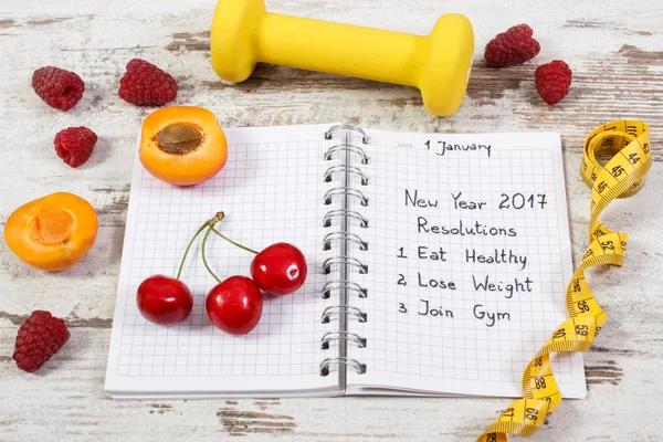 Resoluciones de año nuevo escritas en cuaderno en tablero viejo — Foto de Stock
