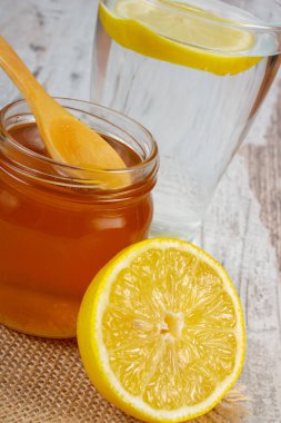 Taze limon bal ve su bir bardak dilim limon ile