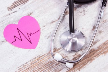 Kağıt kardiyogram çizgi ve ahşap arka plan, tıp ve sağlık kavramı stetoskop ile kalp