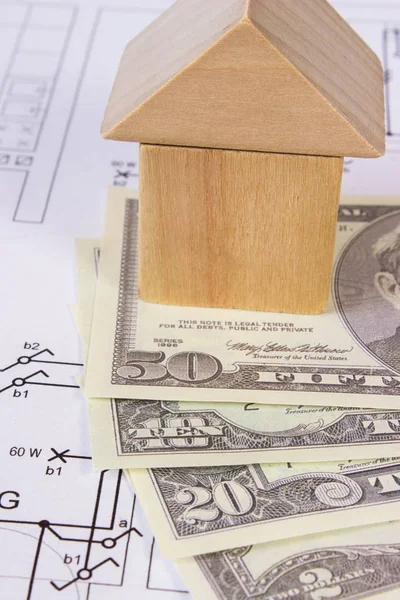House of wooden blocks and currencies dollar on construction drawing, building house concept