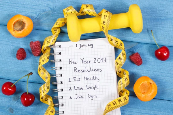 New year resolutions written in notebook on blue board — Stock Photo, Image