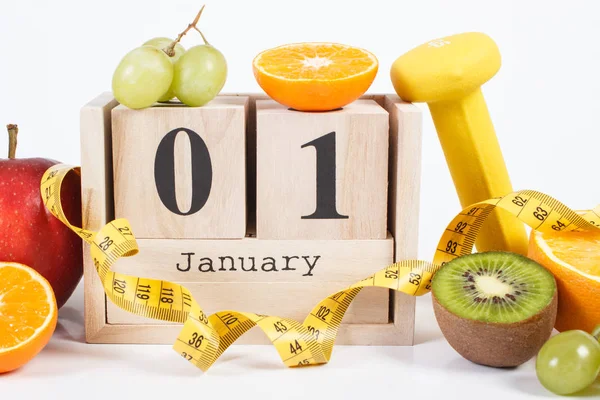 Cube calendar, fruits, dumbbells and tape measure, new years resolutions — Stock Photo, Image
