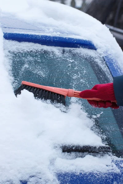 Hand av kvinna med pensel och ta bort snö från bilen och vindruta — Stockfoto