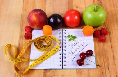 Meyve, sebze ve santimetre ile defter, zayıflama ve sağlıklı gıda